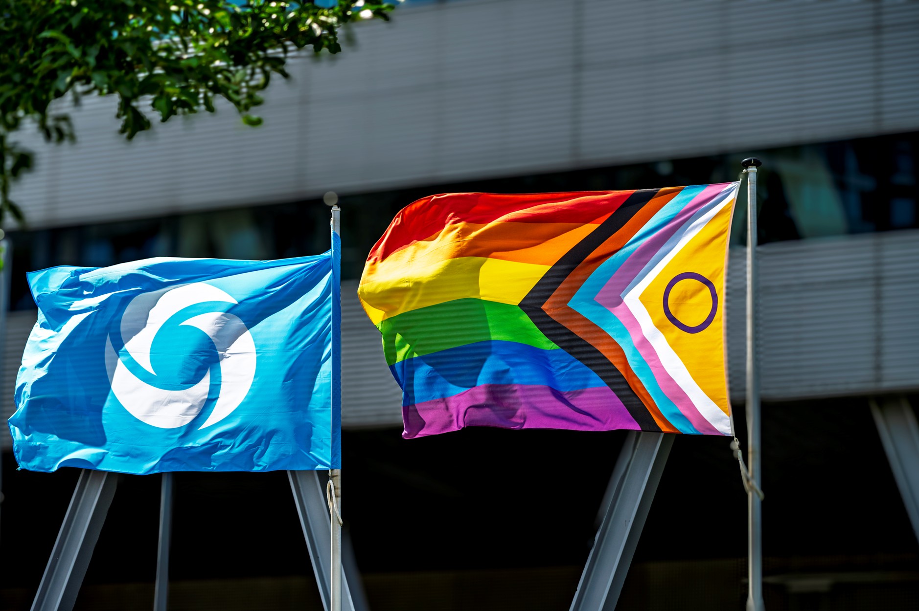 Een vlag van Waternet en een Pridevlag wapperen voor het hoofdkantoor van Waternet